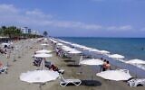 Les gens se rassemblent sur la plage Mackenzie dans la ville côtière de Larnaca sur l'île méditerranéenne de Chypre, le 23 mai 2020. (Crédit : Etienne TORBEY / AFP)