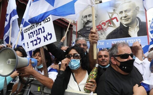 Des partisans de Netanyahu agitent des drapeaux et une affiche représentant le Premier ministre Benjamin Netanyahu et l'officier français Alfred Dreyfus, injustement condamné pour trahison en 1895, lors d'une manifestation devant le tribunal de Jérusalem le 24 mai 2020. (Photo par Menahem KAHANA / AFP) Des partisans de Netanyahu agitent des drapeaux et une affiche représentant le Premier ministre Benjamin Netanyahu et l'officier français Alfred Dreyfus, injustement condamné pour trahison en 1895, lors d'une manifestation devant le tribunal de Jérusalem le 24 mai 2020. (Photo par Menahem KAHANA / AFP)