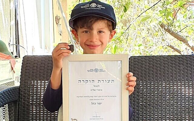 Imri Elya, 6 ans, originaire du kiccoutz Nirim, a découvert la pièce cananéenne au cours d'une randonnée avec ses parents au Tel Gama (ville cananéenne de Yarza) au mois de mars 2020 (Crédit : Autorité israélienne des antiquités)