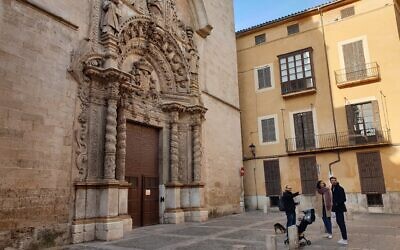 Dani Rotstein, le doigt en l'air, présente à des touristes allemands une église qui était une synagogue dans le passé à Palma de Majorque, le 11 février 2019. (Crédit : Cnaan Liphshiz/ JTA)
