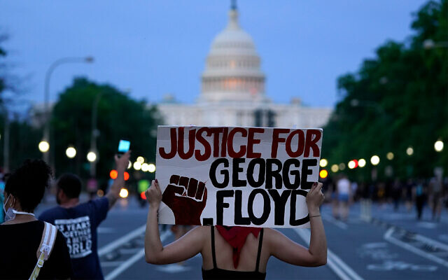 Des manifestants marchent le long de la Pennsylvania Avenue pour protester contre la mort de George Floyd, à Washington, le 29 mai 2020. (Crédit : AP / Evan Vucci) Des manifestants marchent le long de la Pennsylvania Avenue pour protester contre la mort de George Floyd, à Washington, le 29 mai 2020. (Crédit : AP / Evan Vucci)