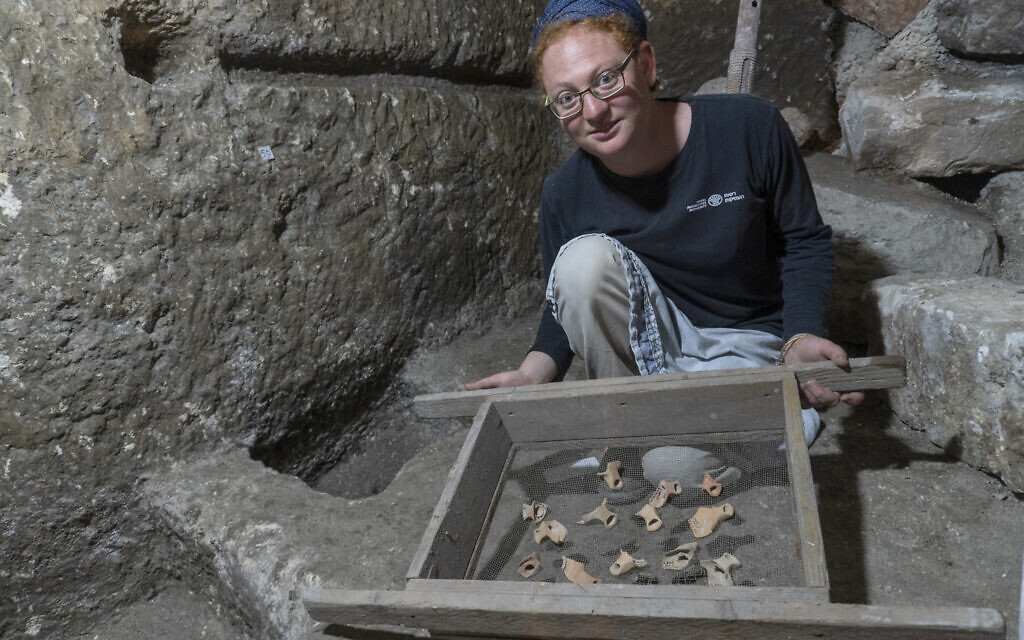 La co-directrice des fouilles Tehila Saldiel montre des artéfacts trouvés sous le Beit Strauss dans la Vieille Ville de Jérusalem, près du mur Occidental, en mai 2020 (Crédit : Shai HaLevi/Autorité israélienne des Antiquités)