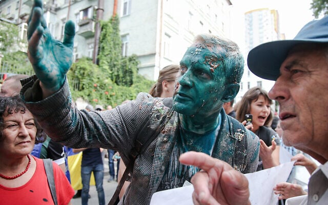 Le fondateur d' l'AntAC Vitaliy Shabunin aspergé d'un liquide antiseptique vert pendant une manifestation anti-corruption en Ukraine, le 17 juillet 2018 (Crédit :  Vyacheslav Ratynskyi / UNIAN)