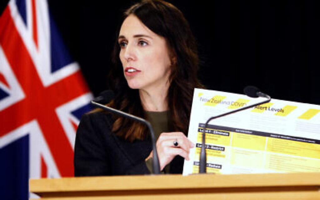 Sur cette photo du 21 mars 2020, la Première ministre néo-zélandaise Jacinda Ardern brandit une carte montrant un nouveau système d'alerte pour le COVID-19 à Wellington, en Nouvelle-Zélande. (AP Photo/Nick Perry)
