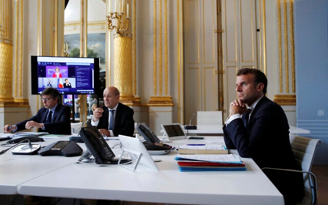 Le président français Emmanuel Macron et le ministre français des Affaires étrangères Jean-Yves le Drian lors d’une vidéoconférence internationale concernant la vaccination, à l'Elysée, à Paris, le 4 mai 2020. (Gonzalo Fuentes / Pool via AP)