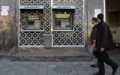 Des Palestiniens passant devant un distributeur de billets de la Banque de Palestine, à Gaza City, le 4 décembre 2008. (Crédit : Hatem Moussa/AP)