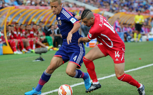 Le Japonais Keisuke Honda, à gauche, et le Palestinien Abdallah Jaber se disputent le ballon lors du match de la Coupe d'Asie de l'AFC entre le Japon et la Palestine à Newcastle, en Australie, le 12 janvier 2014. (Crédit : Rob Griffith/AP) Le Japonais Keisuke Honda, à gauche, et le Palestinien Abdallah Jaber se disputent le ballon lors du match de la Coupe d'Asie de l'AFC entre le Japon et la Palestine à Newcastle, en Australie, le 12 janvier 2014. (Crédit : Rob Griffith/AP)
