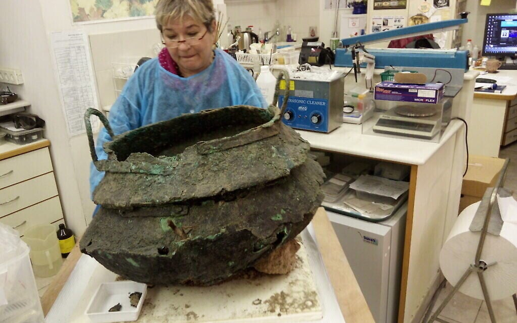 Un conservateur travaille sur un chaudron en bronze trouvé dans un temple cananéen du XIIe siècle avant J.-C. à Lachish. (T. Rogovski)
