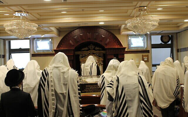 Des ultra-orthodoxes prient, masqués, à Meah Shearim, le 21 mai 2020; (Crédit : Sam Sokol)