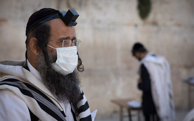 Des hommes juifs prient au Mur occidental, le lieu de prière le plus saint du judaïsme, dans la Vieille Ville de Jérusalem. 19 avril 2020. (Nati Shohat/Flash90) Des hommes juifs prient au Mur occidental, le lieu de prière le plus saint du judaïsme, dans la Vieille Ville de Jérusalem. 19 avril 2020. (Nati Shohat/Flash90)