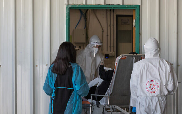 Des employés de Magen David Adom en équipement de protection devant l'hôpital Shaare Zedek à Jérusalem, le 30 avril 2020. (Crédit : Nati Shohat/Flash90)