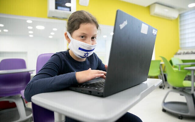 Une élève porte un masque de protection alors que les élèves depuis le cours préparatoire jusqu'au CE2 sont retournés à l'école pour la première fois depuis l'apparition du coronavirus, le 3 mai 2020. (Olivier Fitoussi/Flash90) Une élève porte un masque de protection alors que les élèves depuis le cours préparatoire jusqu'au CE2 sont retournés à l'école pour la première fois depuis l'apparition du coronavirus, le 3 mai 2020. (Olivier Fitoussi/Flash90)