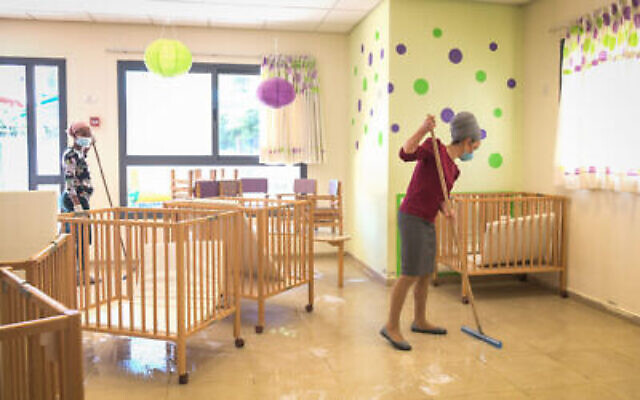 Le personnel d'une crèche du réseau Emunah nettoie l'établissement, à Modiin, le 7 mai 2020. (Crédit : Yossi Zeliger/Flash90)