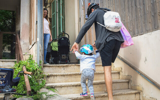 Des enfants et leurs enseignants lors du retour dans un jardin d'enfants à Tel Aviv, le 10 mai 2020 (Crédit : Avshalom Sassoni/Flash90)