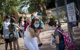 Des élèves et des enseignants portent des masques de protection à leur retour à l'école, à l'école Hashalom de Mevaseret Zion, près de Jérusalem, le 17 mai 2020. (Crédit : Yonatan Sindel/Flash90)