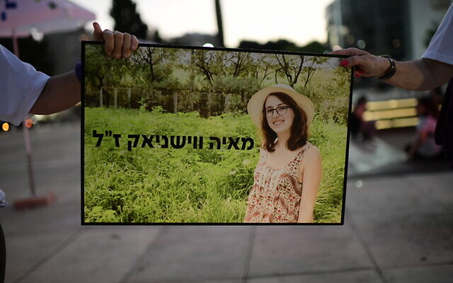 Des manifestants contre la violence envers les femmes montrent une photo de Maya Vishnyak, qui a été étranglée lors d'un acte de violence domestique, alors qu'ils participent à un rassemblement sur la place Habima à Tel Aviv, le 18 mai 2020. (Tomer Neuberg/Flash90)