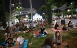 Des Israéliens piquent-niquent sur la place Dizengoff de Tel Aviv, le 20 mai 2020, alors que tous les restaurants, cafés et bars étaient encore fermés sauf pour les livraisons et les plats à emporter dans le contexte de la crainte de la propagation du coronavirus. (Crédit : Miriam Alster/Flash90)