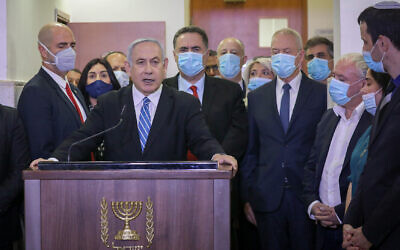 Le Premier ministre Benjamin Netanyahu faisant une déclaration avant d'entrer dans la salle d'audience du tribunal de Jérusalem, le 24 mai 2020, pour le début de son procès pour corruption. À ses côtés, de gauche à droite, des députés et des ministres du Likud, dont Amir Ohana, Miri Regev, Nir Barkat, Israel Katz, Tzachi Hanegbi et Yoav Gallant. (CRédit: Yonathan Sindel/Flash90)