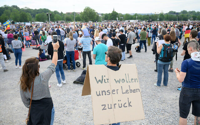 Un manifestant porte une pancarte avec l'inscription "Nous voulons retrouver notre vie" lors d'une manifestation à Stuttgart, en Allemagne, contre les restrictions sanitaires liées au coronavirus, le 9 mai 2020. (Crédit : Sebastian Gollnow/alliance de photos via Getty Images via JTA) Un manifestant porte une pancarte avec l'inscription "Nous voulons retrouver notre vie" lors d'une manifestation à Stuttgart, en Allemagne, contre les restrictions sanitaires liées au coronavirus, le 9 mai 2020. (Crédit : Sebastian Gollnow/alliance de photos via Getty Images via JTA)
