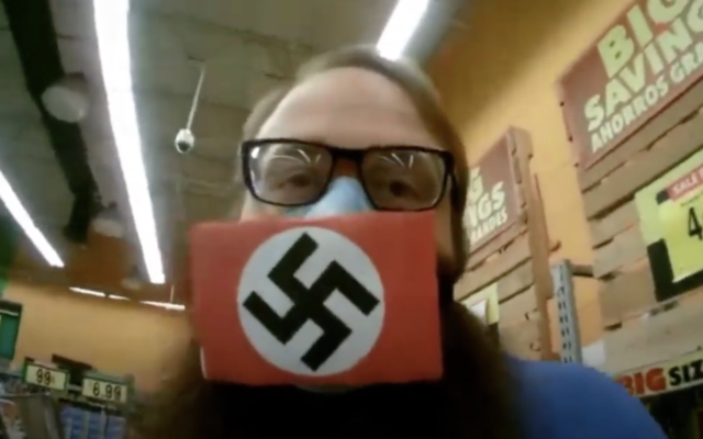 Dustin Hart porte un masque orné d'une croix gammée pour protester contre le confinement. (Capture d'écran YouTube)