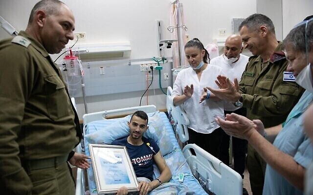 Le chef d'état-major de Tsahal Aviv Kohavi, à doite, et le Col. David Songo remettent une distinction au sergent-chef Shadi Ibrahim, un soldat ayant perdu une jambe après avoir été percuté par une voiture-bélier en Cisjordanie, au centre médical Soroka de Beer Sheva, le 27 mai 2020. (Armée israélienne) Le chef d'état-major de Tsahal Aviv Kohavi, à doite, et le Col. David Songo remettent une distinction au sergent-chef Shadi Ibrahim, un soldat ayant perdu une jambe après avoir été percuté par une voiture-bélier en Cisjordanie, au centre médical Soroka de Beer Sheva, le 27 mai 2020. (Armée israélienne)