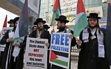 Des hommes juifs ultra-orthodoxes appartenant à Neturei Karta, un petit groupe des Juifs ultra-orthodoxes qui s'opposent à l'existence d'Israël, tiennent des pancartes lors de la manifestation annuelle en mémoire du massacre de 1994 du Tombeau des Patriarches, dans la ville cisjordanienne d'Hébron, le 22 février 2019. (HAZEM BADER / AFP)