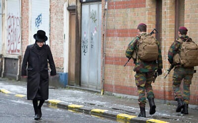 Un enfant juif passe à côté de soldat belges alors qu'is patrouillent lors de services religieux à Antwerp en Belgique, le 24 janvier 2015. (AP Photo/Virginia Mayo)