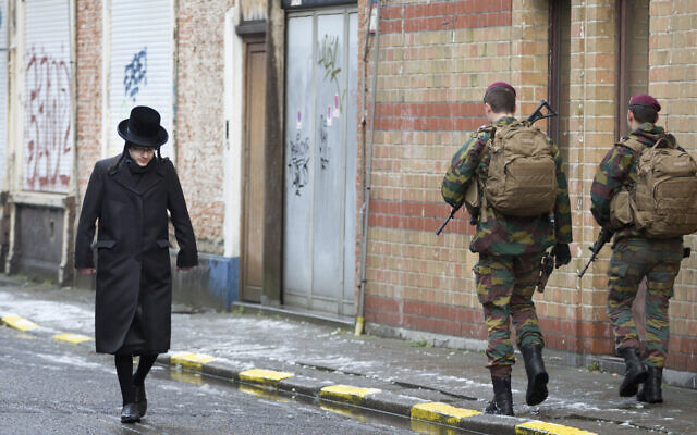 Un enfant juif passe à côté de soldat belges alors qu'is patrouillent lors de services religieux à Antwerp en Belgique, le 24 janvier 2015. (AP Photo/Virginia Mayo)