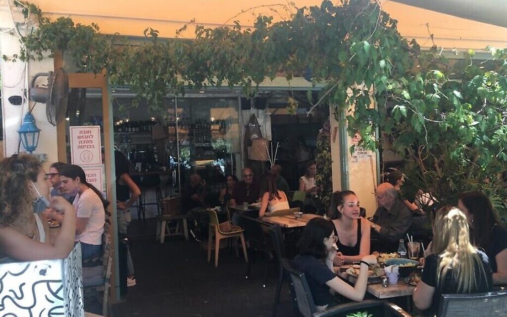 Jeunes Tel-Aviviens au Café Zurik à Tel Aviv le premier jour où les restaurants ont été autorisés à ouvrir après le coronavirus, le 27 mai 2020. (Simona Weinglass/Times of Israel)