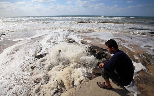 Un Palestinien regarde les eaux usées s'écouler sur la plage, dans le centre de la bande de Gaza, le 22 mars 2010. (Crédit : Wissam Nassar/Flash90) Un Palestinien regarde les eaux usées s'écouler sur la plage, dans le centre de la bande de Gaza, le 22 mars 2010. (Crédit : Wissam Nassar/Flash90)