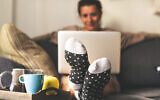 Photo d'illustration : Une femme assise sur un canapé dans son salon (Crédit : Fabio Principe; iStock by Getty Images)