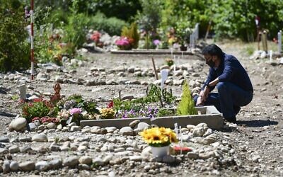 Le Marocain Mustapha Moulay, qui vit en Italie depuis 32 ans, prie à côté de la tombe de sa femme, décédée le 7 avril 2020 du COVID-19, le 5 juin 2020, dans la section musulmane d'un cimetière majoritairement catholique romain de Bruzzano, dans la périphérie de Milan. (Crédit : Miguel MEDINA / AFP)