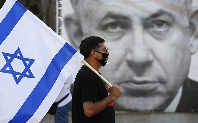 Un manifestant avec le drapeau israélien pendant une manifestation pour dénoncer le projet d'annexion de la Cisjordanie, place Rabin à Tel Aviv, le 6 juin 2020 (Crédit : JACK GUEZ / AFP)