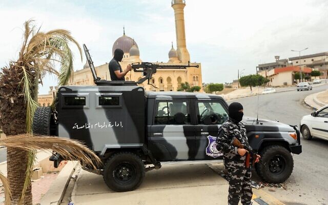 Des membres des forces de sécurité affiliées au ministère de l'Intérieur du gouvernement libyen d'accord national (GNA) se tiennent à un poste de contrôle de fortune dans la ville de Tarhuna, à environ 65 kilomètres au sud-est de la capitale Tripoli, le 11 juin 2020. (Crédit : Mahmud TURKIA / AFP)