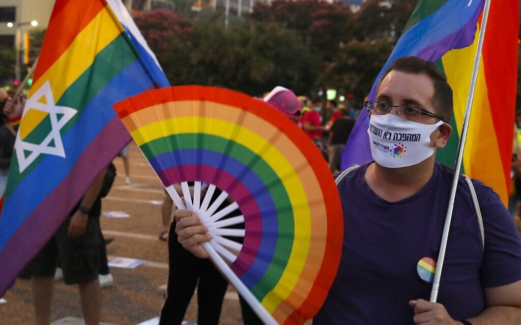 Des participants brandissent des drapeaux arc-en-ciel au défilé annuel de la fierté de Tel Aviv, le 28 juin 2020. (Crédit : JACK GUEZ / AFP)