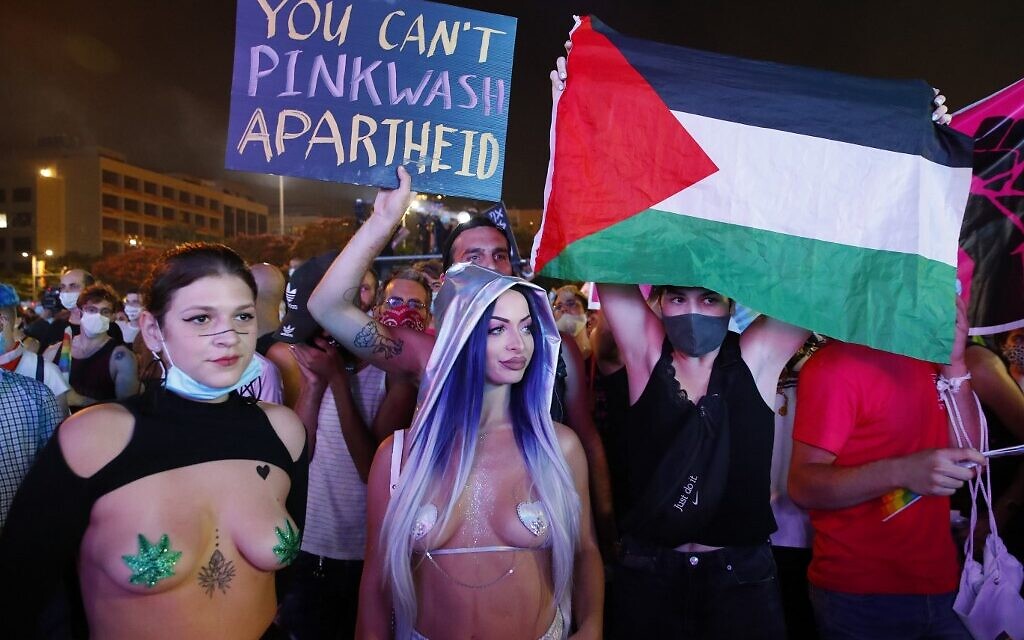 Des participants avec un drapeau palestinien et une pancarte dénonçant le « pink washing » en Israël, au défilé annuel de la fierté de Tel Aviv, le 28 juin 2020. (Crédit : JACK GUEZ / AFP)