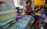 Une femme nourrit des enfants de familles d'immigrants africains clandestins dans un centre du sud de Tel Aviv, le 28 mai 2015. Illustration. (Crédit : Jack Guez/AFP)