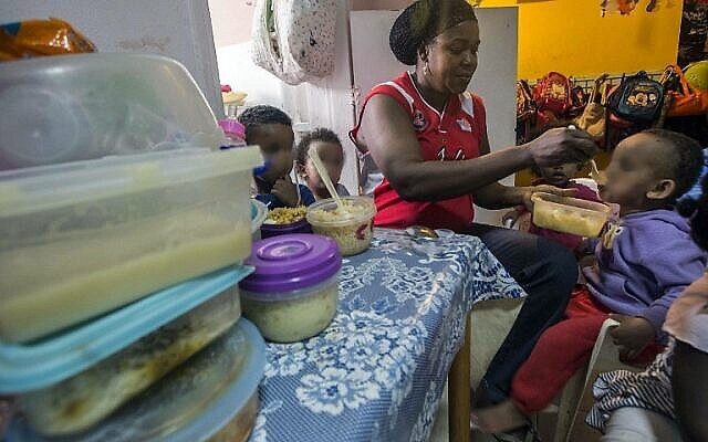 Une femme nourrit des enfants de familles d'immigrants africains clandestins dans un centre du sud de Tel Aviv, le 28 mai 2015. Illustration. (Crédit : Jack Guez/AFP) Une femme nourrit des enfants de familles d'immigrants africains clandestins dans un centre du sud de Tel Aviv, le 28 mai 2015. Illustration. (Crédit : Jack Guez/AFP)