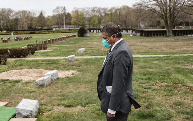 Stanley Parnes, chauffeur de corbillard à la maison funéraire Gutterman, assiste aux funérailles d'une victime du COVID-19 sans famille, par respect, le 15 mai 2020. (Photo par Jonathan Alpeyrie/Polaris Images)