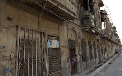 Une jeune Irakienne regarde par la porte de sa maison dans une rue de ce qui était autrefois le quartier juif du centre de Bagdad, en Irak, le lundi 26 septembre 2011. (AP/Karim Kadim)