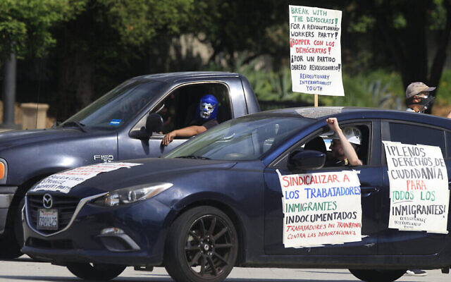 Des travailleurs journaliers de Pasadena et leurs partisans organisent un "rassemblement de voitures sûres COVID-19" pour protester contre l'exclusion des travailleurs de la protection financière dans le cadre de la pandémie actuelle pour les travailleurs immigrés essentiels devant l'hôtel de ville de Pasadena, en Californie, le mercredi 29 avril 2020. (AP Photo/Damian Dovarganes)