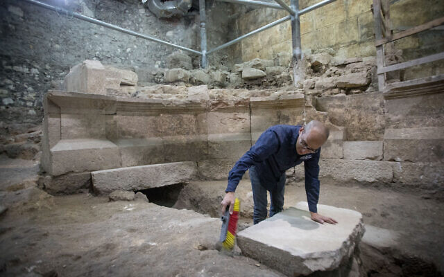 Joe Uziel, archéologue de l'Autorité israélienne des antiquités, nettoie des pierres sur le site  d'une structure de type théâtre romain antique, caché depuis 1700 ans aux abords du mur Occidental, sous la Vieille Ville de Jérusalem, le 16 octobre 2017 (Crédit : Yonatan Sindel/Flash90)