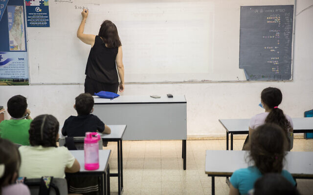 Des élèves et leur enseignante à l'école Hashalom de Mevaseret Sion, près de Jérusalem, le 17 mai 2020. (Yonatan Sindel/Flash90) Des élèves et leur enseignante à l'école Hashalom de Mevaseret Sion, près de Jérusalem, le 17 mai 2020. (Yonatan Sindel/Flash90)