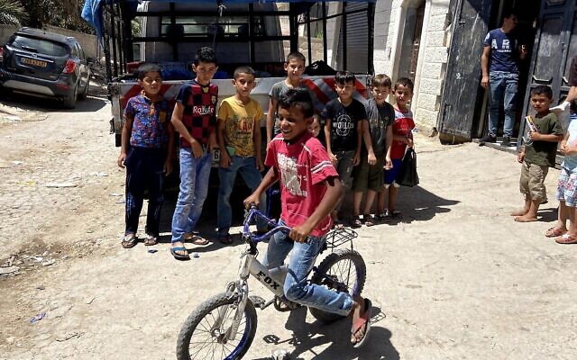 Des enfants posent pour une photo dans le village palestinien de Fasa'il, dans la vallée du Jourdain, le 10 juin 2020. (Jacob Magid / Times of Israel)