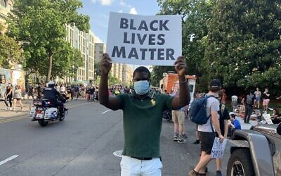 Noel Karl Lebondzo tient un panneau "Black Lives Matter" sur la 16ème rue à Washington, DC, à quelques pâtés de maison de la Maison Blanche, le 6 juin 2020. (Times of Israel)