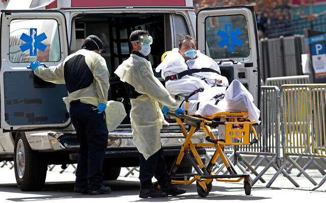 Un patient est transporté du centre hospitalier d'Elmhurst vers une ambulance en attente, dans le quartier du Queens à New York, le 7 avril 2020. (AP/Kathy Willens)