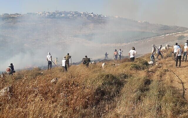 Des résidents de l'implantation de Givat Ronen tentent d'éteindre un feu devant leur avant-poste, le 17 juin 2020. (Crédit : Services d'incendie et de secours d'Israël) Des résidents de l'implantation de Givat Ronen tentent d'éteindre un feu devant leur avant-poste, le 17 juin 2020. (Crédit : Services d'incendie et de secours d'Israël)