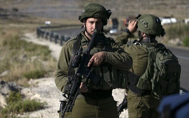 Des soldats israéliens montent la garde à proximité de la scène d'une possible attaque à la voiture bélier autour de l'implantation d'Halamish en Cisjordanie, le 29 mai 2020. (Abbas Momani/AFP) Des soldats israéliens montent la garde à proximité de la scène d'une possible attaque à la voiture bélier autour de l'implantation d'Halamish en Cisjordanie, le 29 mai 2020. (Abbas Momani/AFP)
