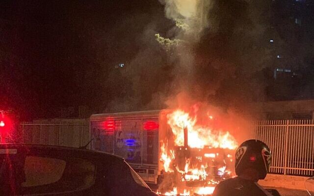 Des pompiers israéliens s'activent pour éteindre un véhicule en feu à Jaffa, le 13 juin 2020, alors que les manifestations se poursuivent contre un projet de la ville de construire un abri pour SDF sur un ancien cimetière musulman. (Pompiers israéliens, Dan District)