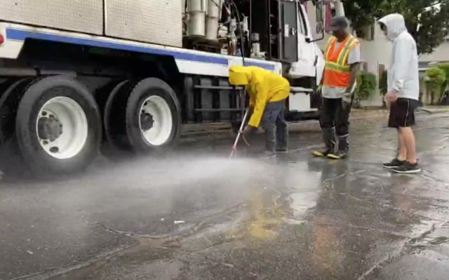 Capture d'écran d'une vidéo d'employés municipaux nettoyant des graffiti antisémites de la route devant le cimetière des Portes de Prière, à la Nouvelle Orléans, le 8 juin 2020. (WWL-TV)
